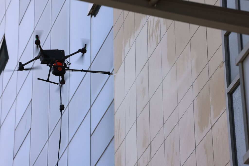 Барилгын гадна фасад, гэрлэн дохиог тусгай төхөөрөмж ашиглан угааж байна